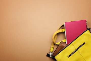 Bright colored women's accessories on a brown background. Lay flat, top view.