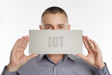 The concept of business, technology, the Internet and the network. Young businessman showing inscription: IOT