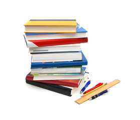 back to school: stack of books with ruler and pen on  white background