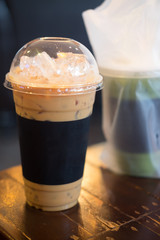 Glass of ice latte coffee on wooden table