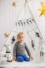 The little boy is playing near the wigwam. Boy playing with toys. © Inna Darda