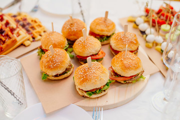 Mini burgers on a tray. Food for a party.