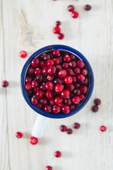 fresh cranberries on white wooden surface