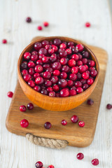fresh cranberries on white wooden surface