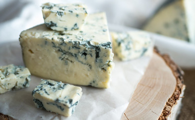 Blue cheese dorbly on parchment paper in the kitchen close up