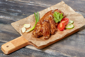 Crispy baked chicken wings on wooden board