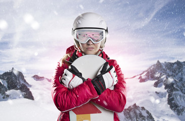 Fototapeta na wymiar portrait einer frau mit snowboard, helm und skibrille vor gebirge panorama