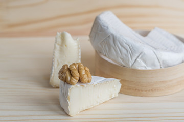 camembert and walnut on wooden background