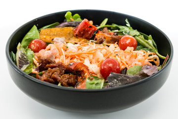 Delicious fresh salad with tomatoes, lettuce, eggplant, zucchini, cheese, parma ham and olive oil.