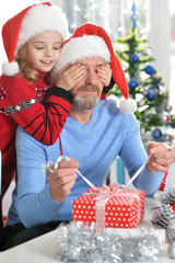Obraz na płótnie Canvas grandfather with girl preparing for Christmas 