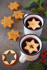 Two mugs of hot red mulled wine spices and gingerbread