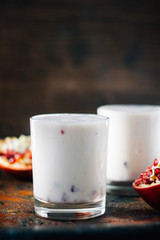 Traditional indian drink - lassi - cold yougurt dessert with the pomegranate seeds.