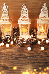 glow candle with lantern and bokeh with pine cone in christmas season concept