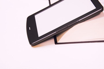 Fine e-book next to a thick paper book. New paper technologies. Replacing paper books. Convenience and comfort of reading. White background. Isolated.