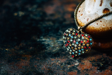 Valentine's day concept - heart jewellery pendant on black background.