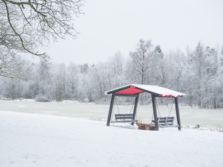 Winter gazebo in the Park. Winter landscape with snow and lonely tree. Winter background.