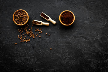 Coffee background. Roasted beans and ground coffee in bowls and scoops on black table top view copyspace