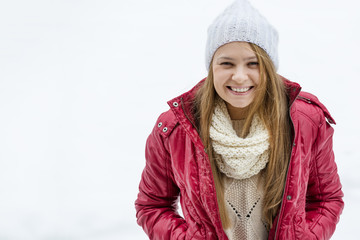 Girl in red jacket enjoing with first snow. Happy winter time.
