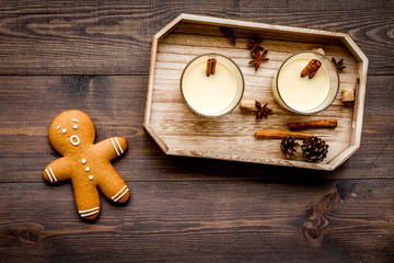 Eggnog for christmas evening. Two glasses near gignerbread cookie on dark wooden background top view
