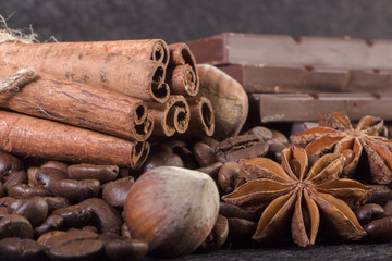 Close-up, roasted coffee seeds, tubberry, cinnamon sticks and chocolate.