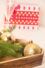Christmas decoration set in red basket on white wooden desk. Bright and jouful new year.