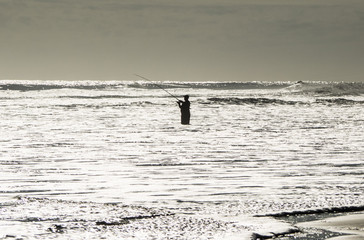 Fototapeta na wymiar A fisherman in the ocean.