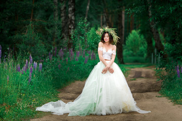 Portrait of a beautiful bride in a white dress and a wreath of F
