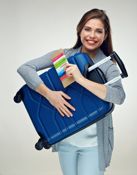 Happy tourist woman holding travel case, tickets, passport, cred