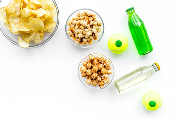 Snacks for watching TV. Crisps, popcorn, rusks near drinks on white background top view copyspace