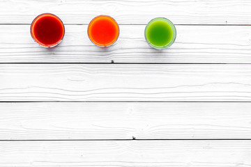 Wellness elements. Colorful detox drinks with vegetables  on white wooden background top view copyspace