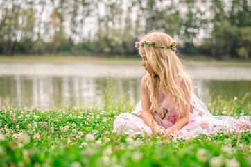 little lonely girl sitting in the grass by the river © katarinagondova