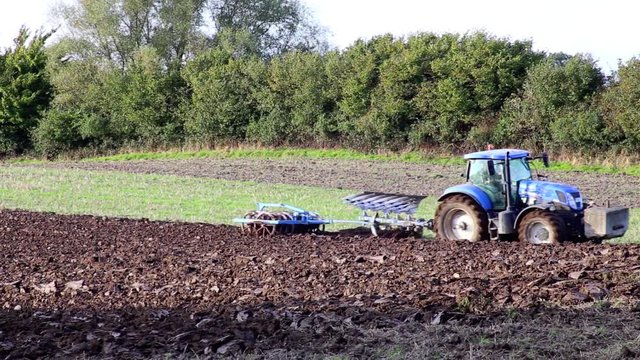 Traktor mit Pflug pfl&uuml;gt Acker um, Abendlicht Full HD Video 1080, 25 fps