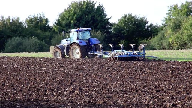 Traktor mit Pflug pfl&uuml;gt Acker um, Abendlicht Full HD Video 1080, 25 fps