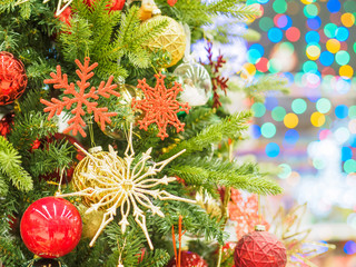 Bright and beautifully decorated with toys Christmas tree against shiny illuminated soft focused background. Christmas and New Year concept.