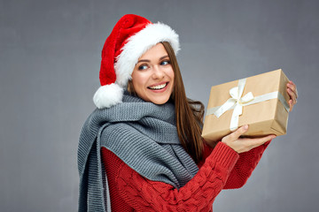 Smiling woman wearing christmas hat holding paper gift box and l