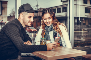 Happy young couple is using a smartphone