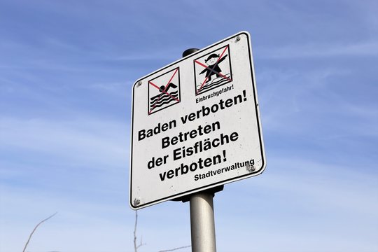Warnschild: Baden verboten, betreten der Eisfläche verboten
