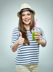 woman holding glass with green smoothie