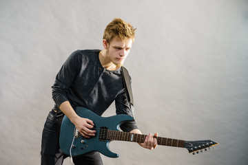 Young man playing electric guitar