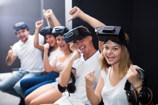 Group of cheerful friends are wearing virtual reality goggles