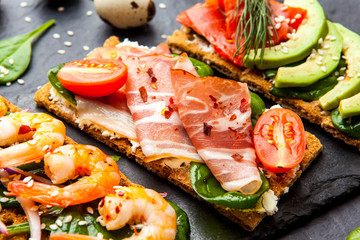 Brushetta set on dark background. Variety of small sandwiches. D