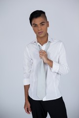 Portrait of transgender woman holding tie