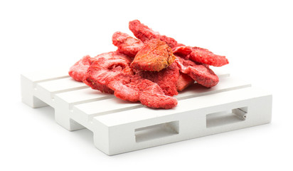 Freeze dried strawberries on a pallet isolated on white background.