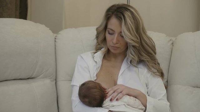 A mom is nursing a baby