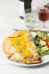 italienische Pizza Calzone auf einem Teller mit Salat