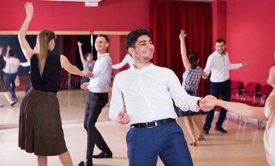 Glad group people dancing lindy hop in pairs