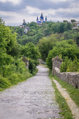 Remains of city walls in Kamianets Podilskyi, Ukraine. Orthodox Cathedral of Saint George on background