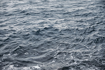 Fototapeta premium The water surface is gray-blue with white foam.