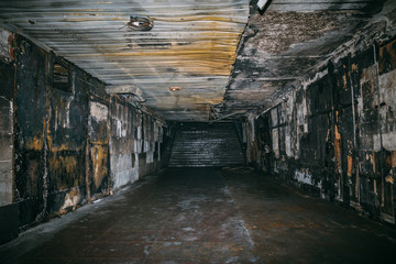 Burned underground pedestrian crossing after a fire or terrorist attack, walls in soot and smoke