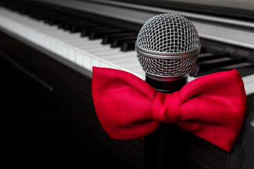 Piano musical instrument and microphone with tie a red butterfly concept of romance, love and...